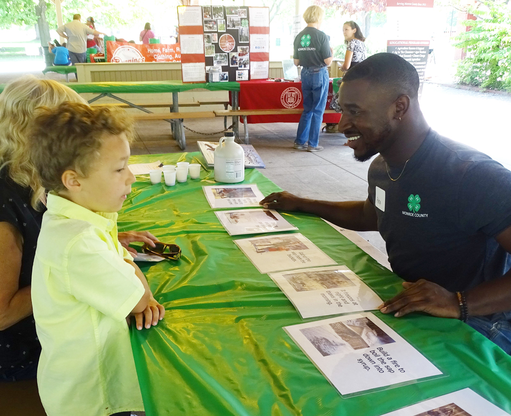 4-H volunteer & Urban Fellow Alexander Leonty explains the process of making maple syrup.